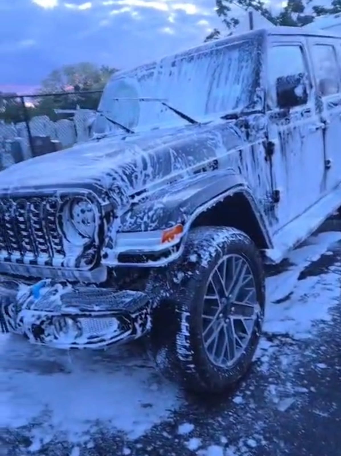 Jeep covered in snow foam during mobile carwash