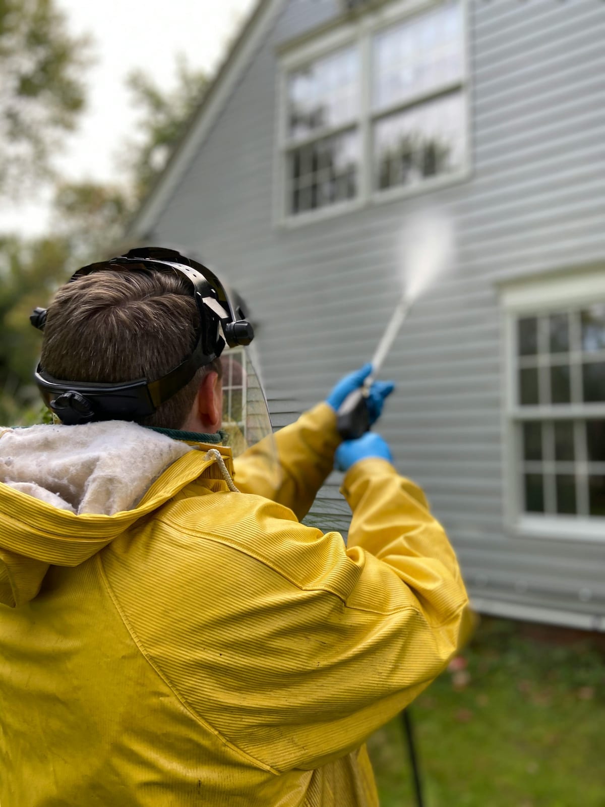 Worker pressure washing outdoor patio pavers