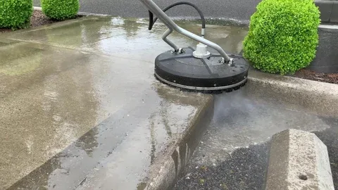 Close-up of pressure washer cleaning a brick patio